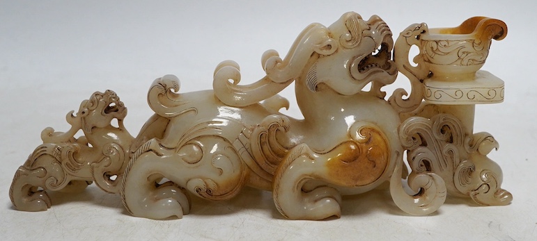 A Chinese archaistic white and russet jade lion-dog group, 20cm long. Condition - good